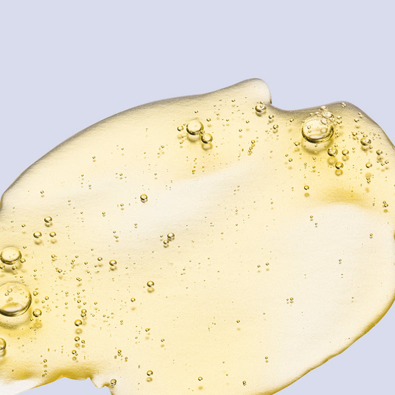 Close-up of a small puddle of vitamin D oil on a table. The oil is golden yellow and has a smooth, liquid texture. Vitamin D is a commonly used PCOS supplement that may help manage PCOS symptoms, particularly by supporting hormonal balance and improving insulin sensitivity.