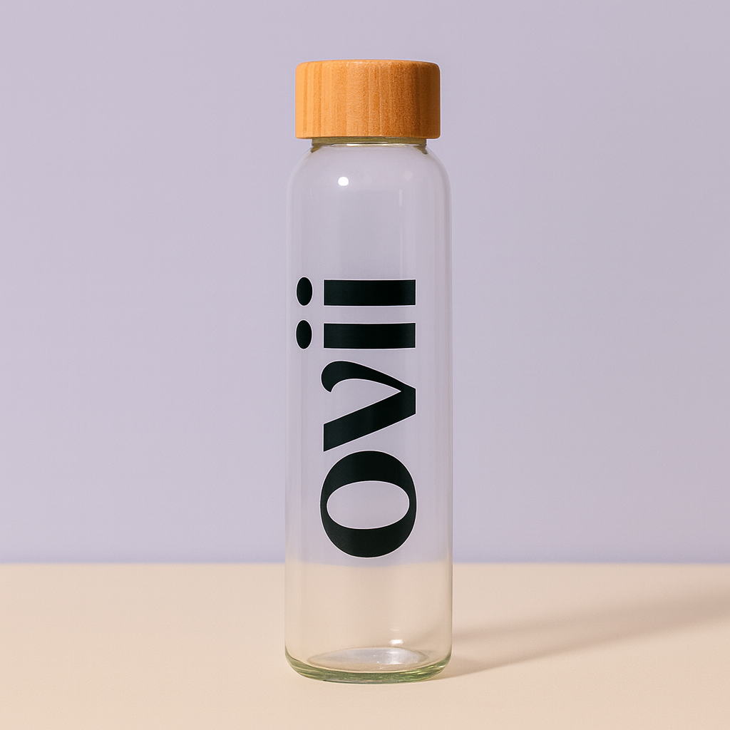 Clear glass water bottle with a wooden cap on a light purple background